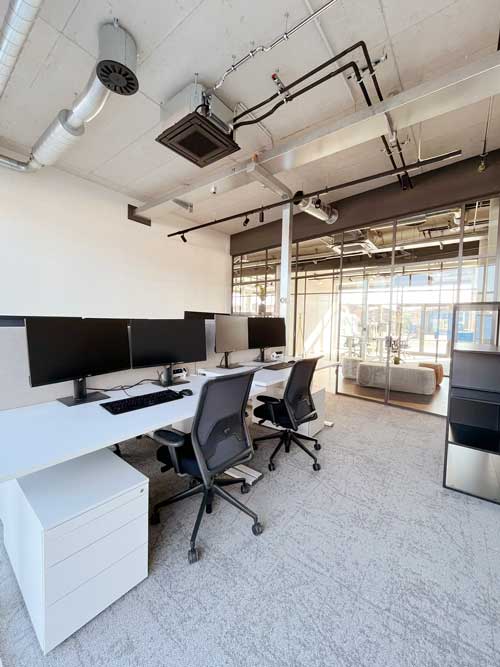 Modernes Büro mit Glaswänden und mehreren Arbeitsplätzen